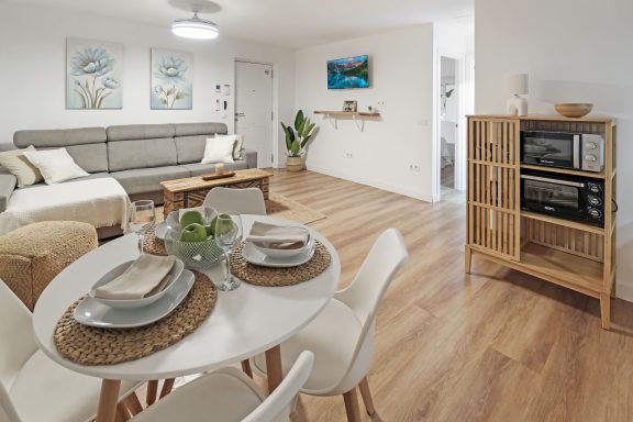 Sala de estar moderna con sofá, mesa de comedor y decoración minimalista.